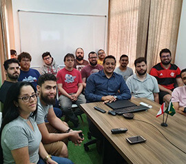 Questrade brazilian employees sit around the table