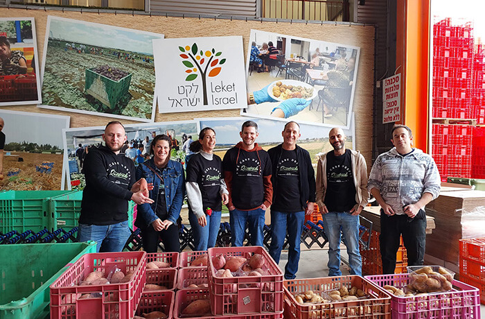 People in volunteering work behind several boxes with food for donation