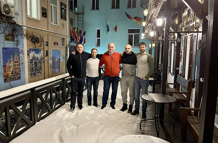Five men standing outside the office, in the snow
